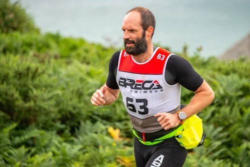 Breca director Jonathan Littlewood running in a wetsuit