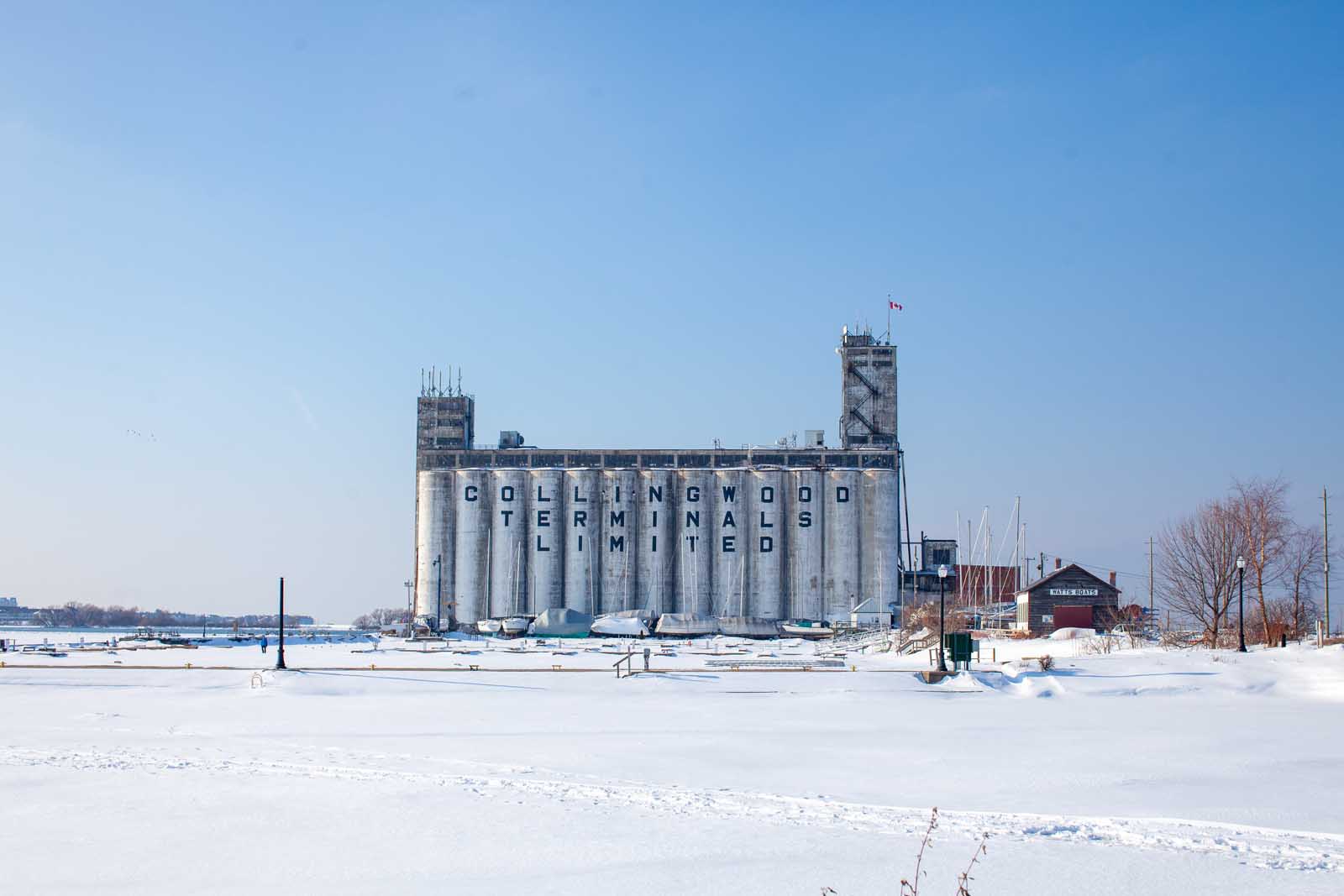 Collingwood Terminals Grain elevator on a sunny day in winter with snow in the foreground.