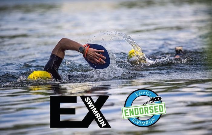 Two men in wetsuits swimming in a lake with hand paddles during the EX & Envol training camp #2 Two men in wetsuits swimming in a lake with hand paddles during the EX & Envol training camp #2
