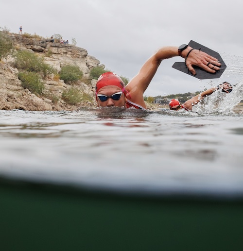 A swimrunner swimming with a high head position and big paddles