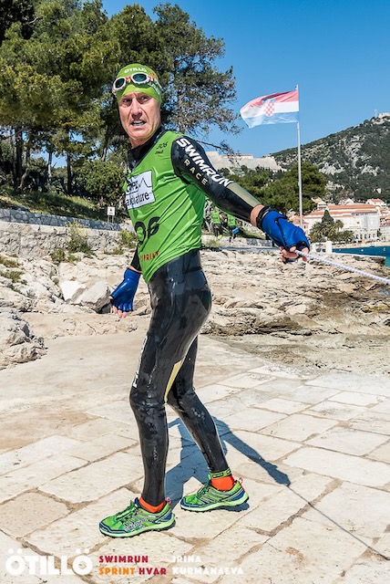 A swimrunner wearing a green top and hat at the start of 2nd run A swimrunner wearing a green top and hat at the start of 2nd run