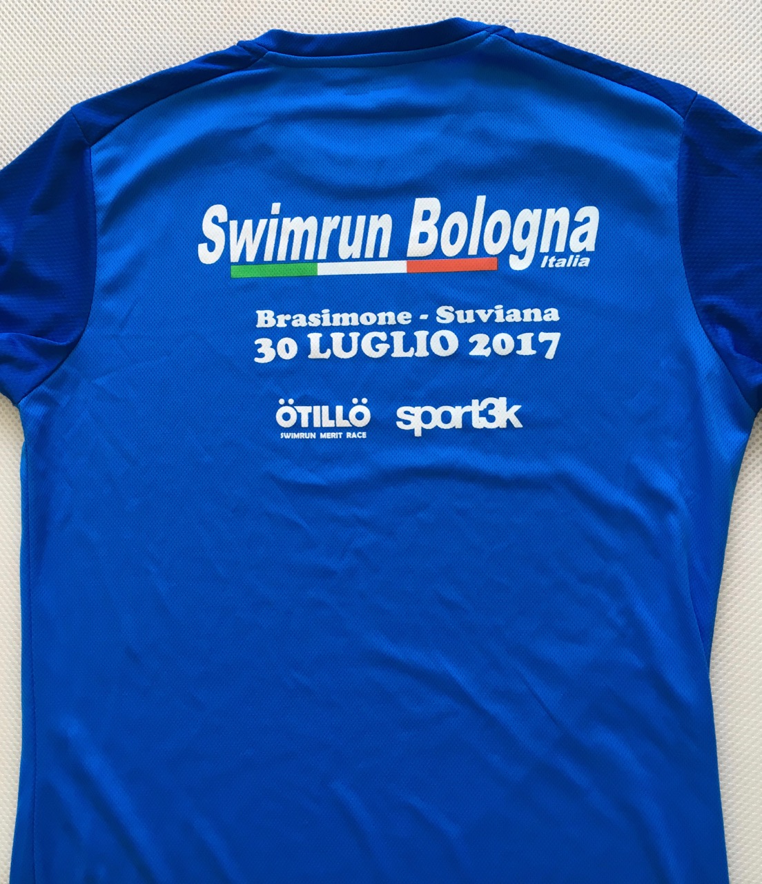 A blue T shirt with SwimRun Bologna written on it