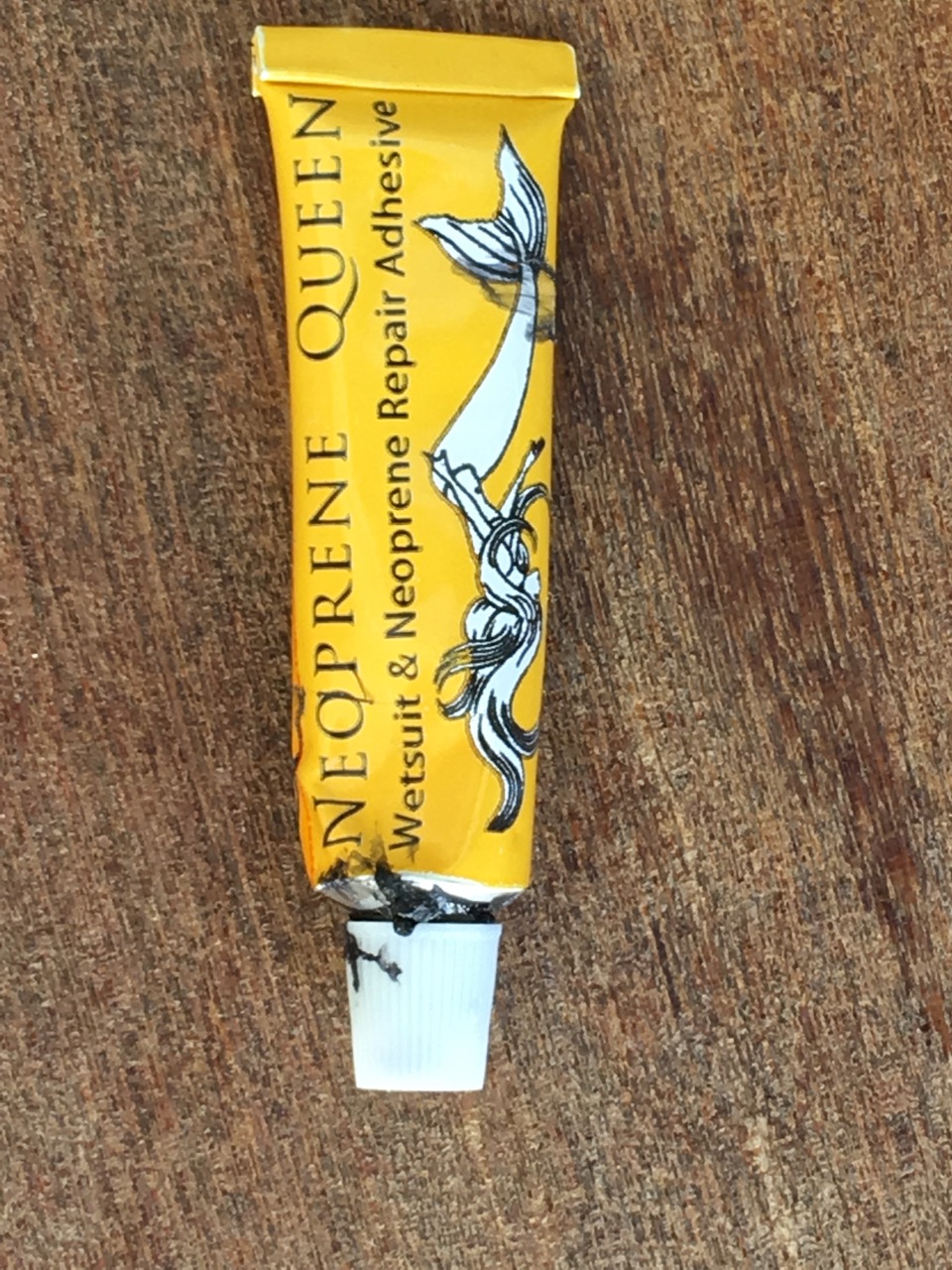 A yellow tube of neoprene adhesive for repairing a SwimRun wetsuit