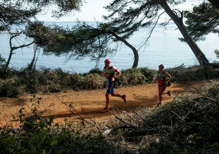 At the Otillo Cannes swimrun event, with two athletes running under the trees