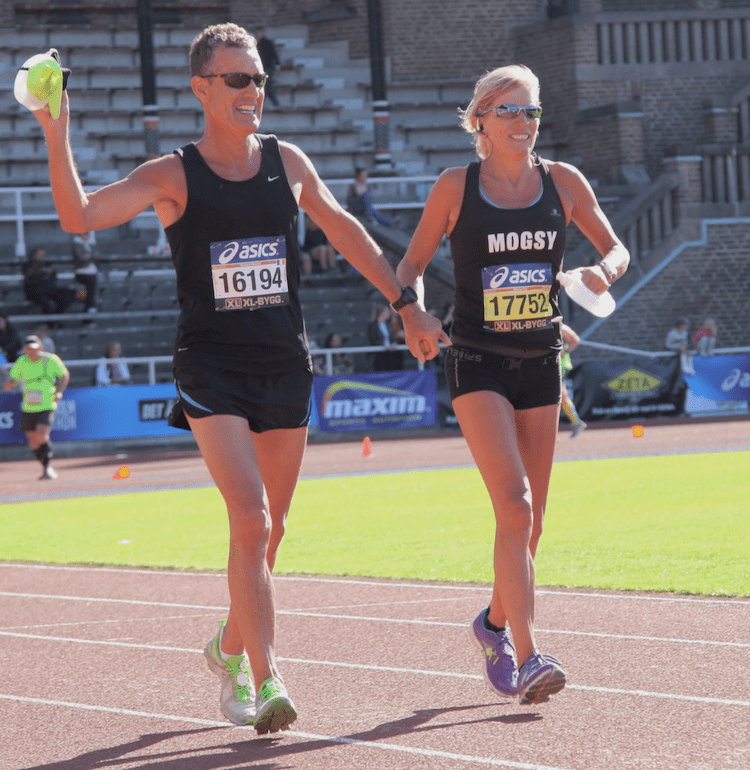 Two runners wearing black at the Stockholm Marathon Finish line, inside the old olympic Stadium.