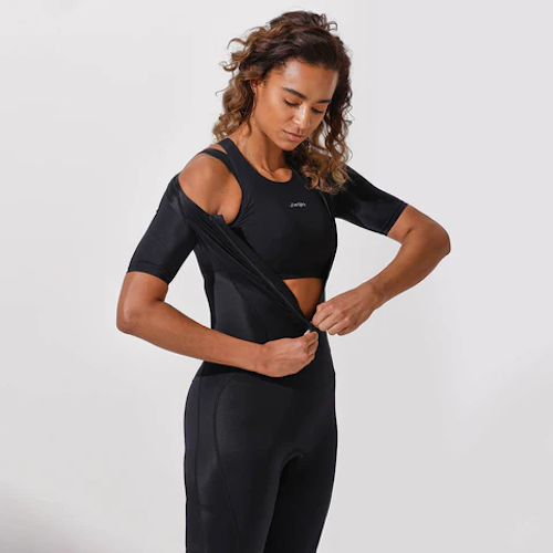 A woman wearing Swijin undergarments zipping up a wetsuit