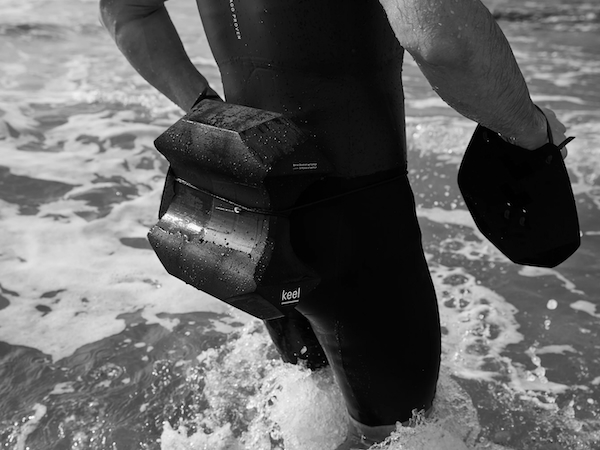 A swimmer at the edge of the sea wearing an ARK Sports Keel swimrun pull buoy A swimmer at the edge of the sea wearing an ARK Sports Keel swimrun pull buoy