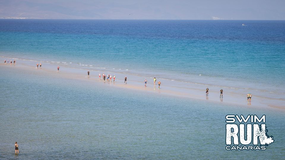 Swimrun competitors running on a sandbar on the Canary Islands. Swimrun competitors running on a sandbar on the Canary Islands.