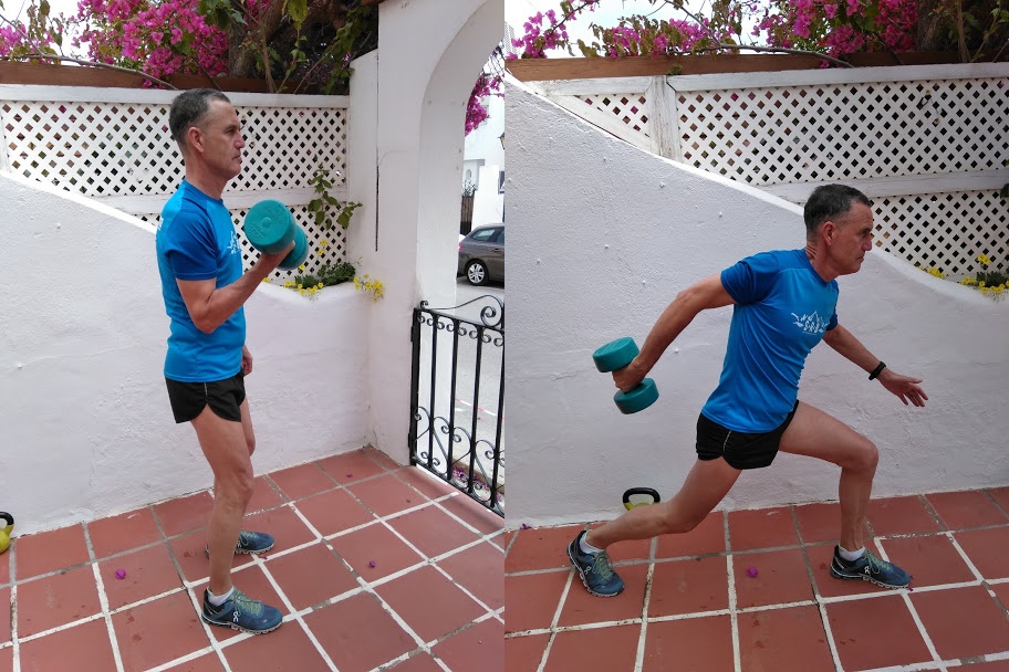 A man in a blue top demonstrating a reverse lunge with a weight.