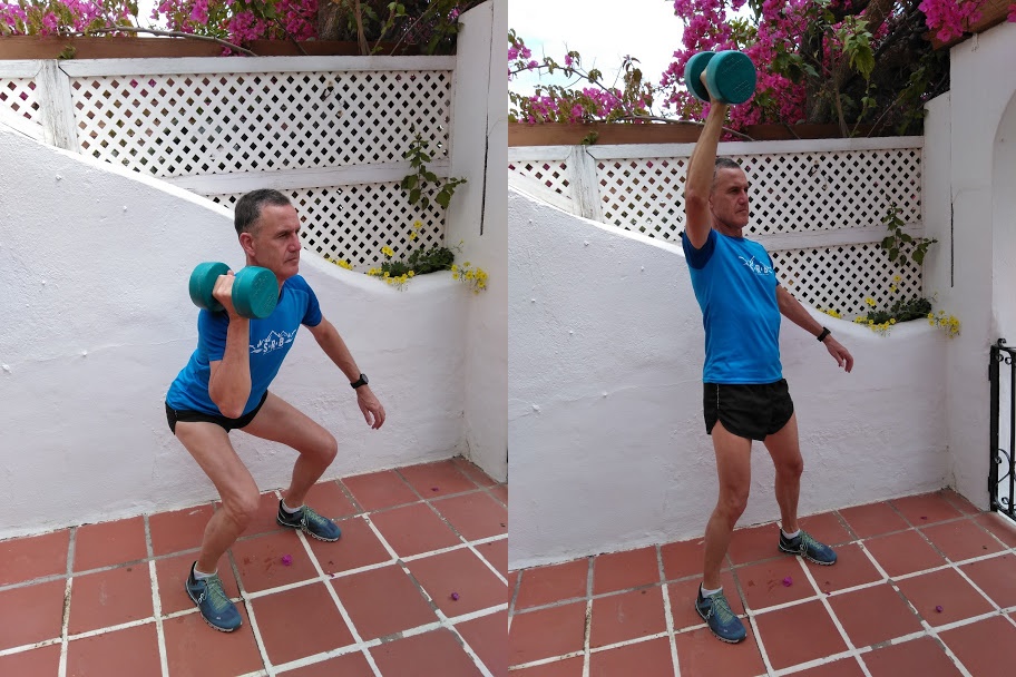 A man in a blue top demonstrating an overhead arm exercise.
