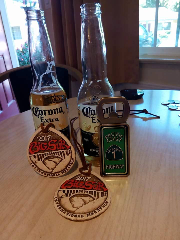 Two bottles of Corona beer on a table with two finishers medals from the Big Sur marathon