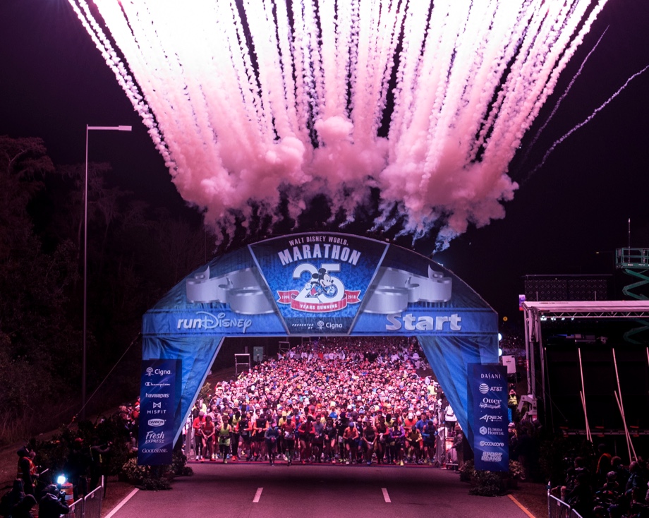 The start of the Disney marathon showing a blue start arch and pink fireworks.
