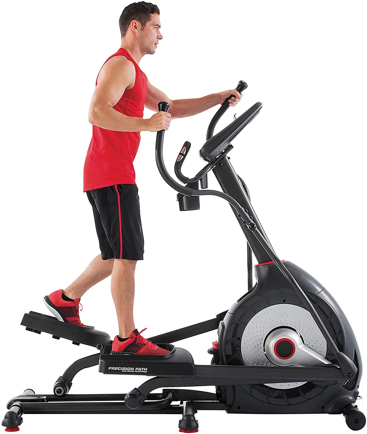 A man in a red top and black shorts exercising on a Schwinn 430 elliptical trainer