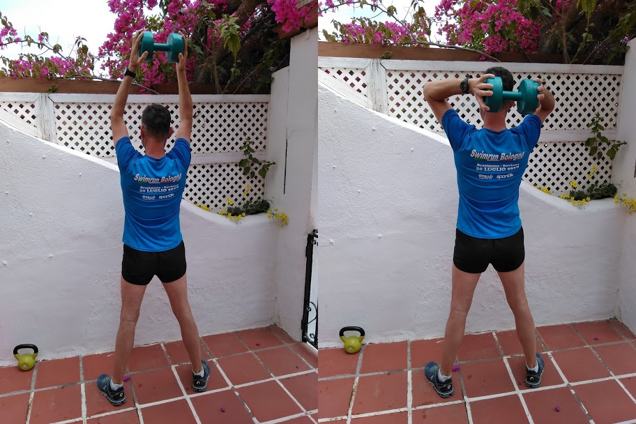 A man in a blue top demonstrating a tricep curl exercise.