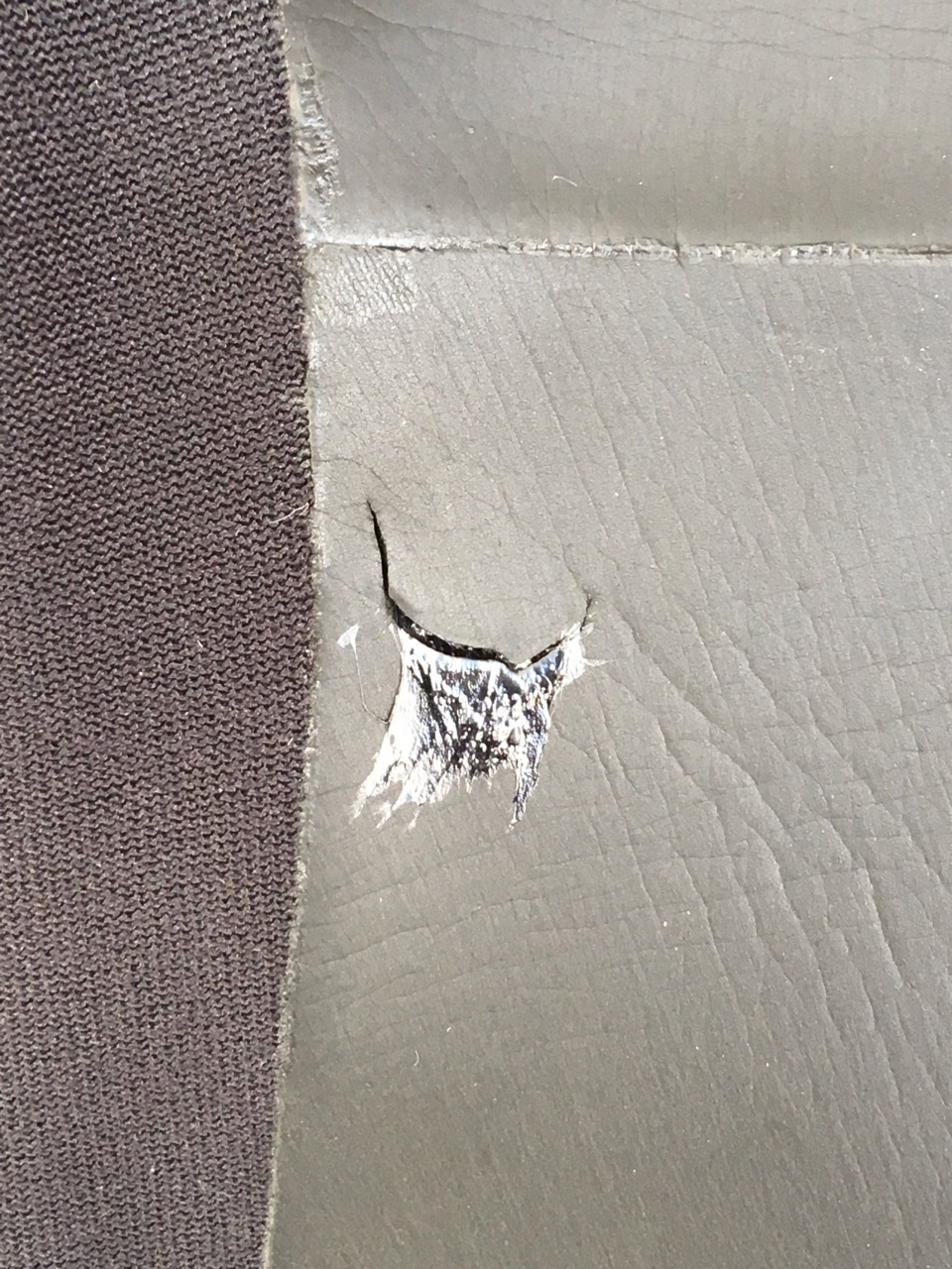 A close up of a repair to a rip in the neoprene of a Swim Run wetsuit